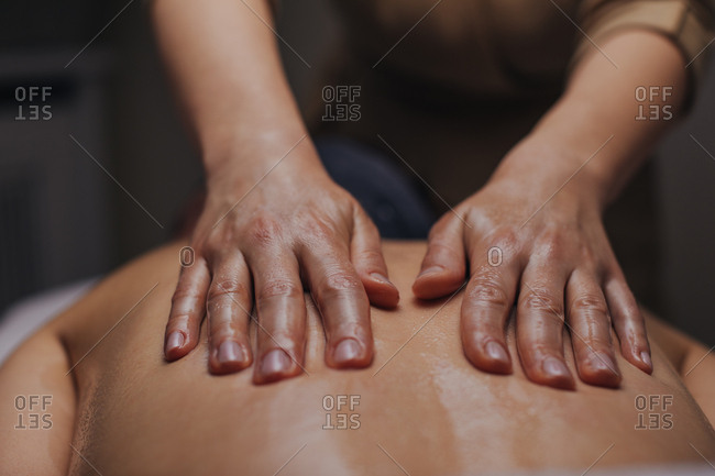 Close up of hands of unrecognizable woman masseuse doing back massage.