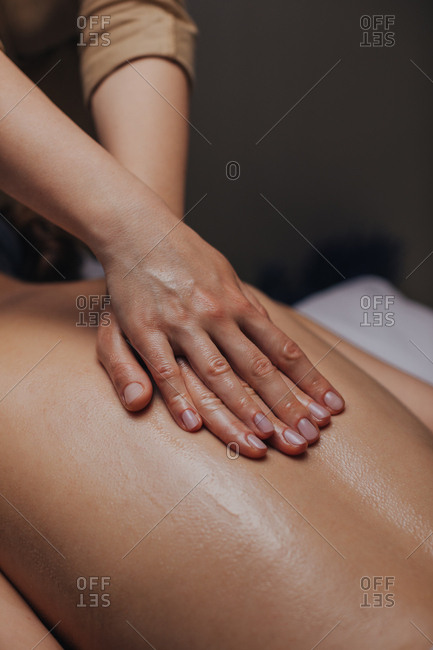 Close up of hands of unrecognizable woman masseuse doing back massage.