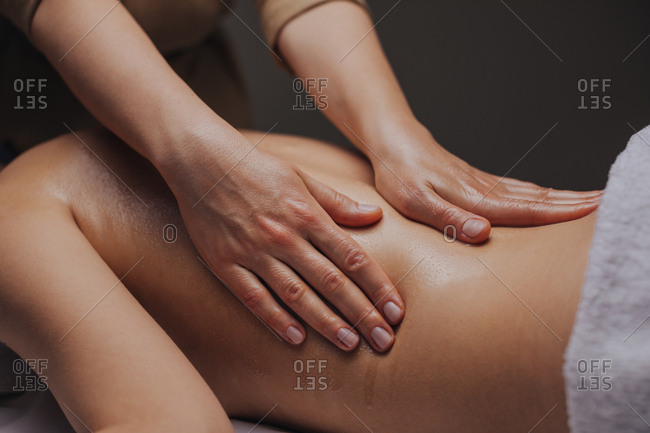 Close up of hands of unrecognizable woman masseuse doing back massage.