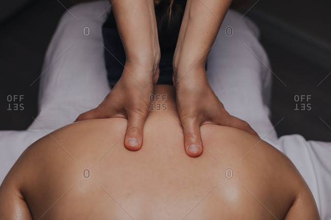 Hands of unrecognizable woman masseuse doing shoulders massage.