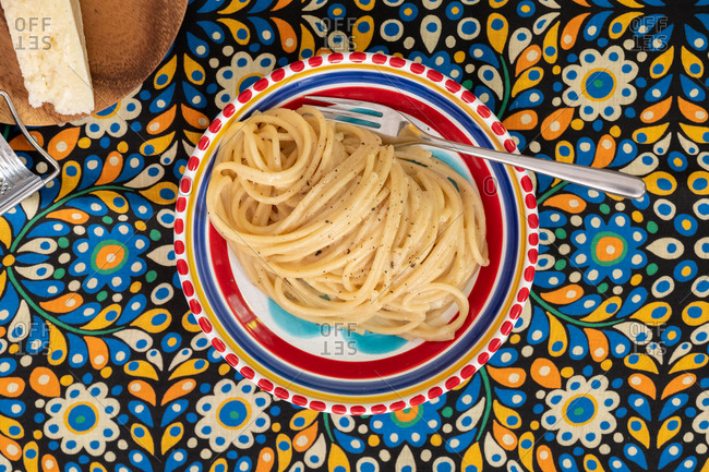 Cacio e pepe pasta in a dish on a floral background