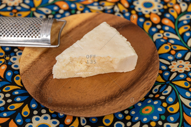 A wedge of parmesan cheese on a wooden board