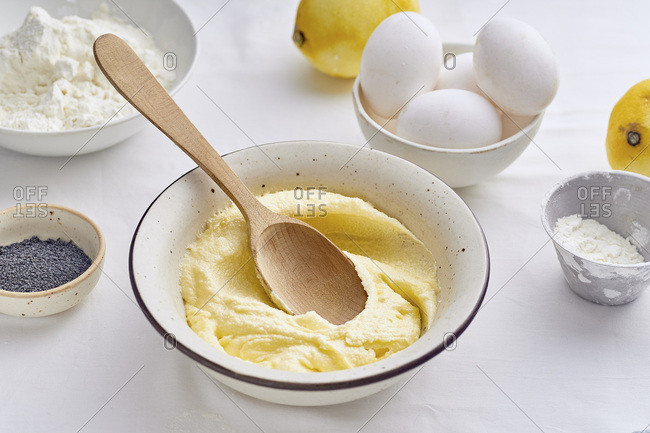 Mixing butter and sugar with wooden spoon while cooking lemon cake