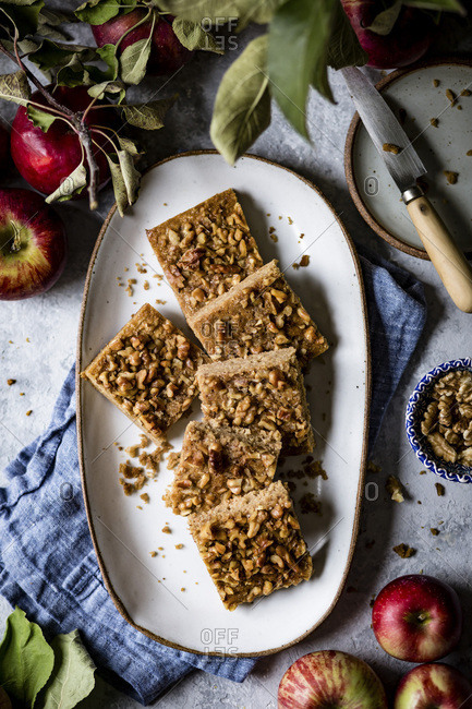 An apple snack cake cut into squares placed on an oval plate.