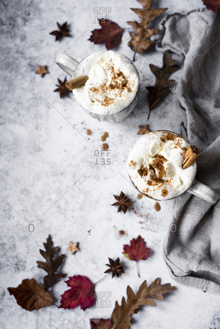 Pumpkin Spiced Latte With Whipped Cream Topping And Cinnamon Dusting Surrounded By Leaves And Spices