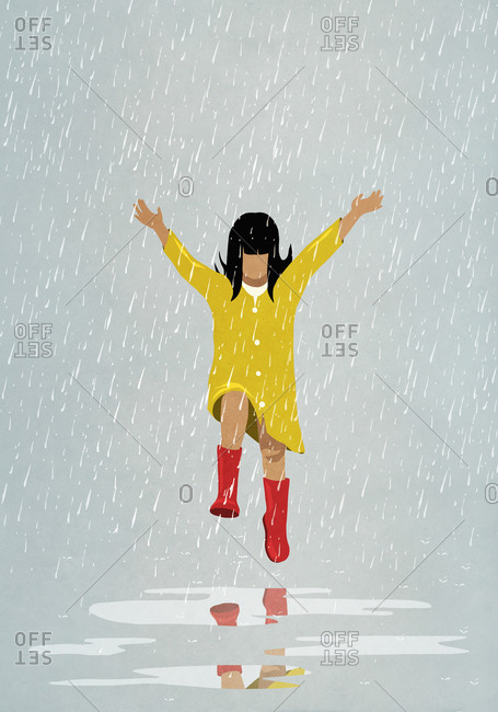 Carefree girl jumping in rain puddles