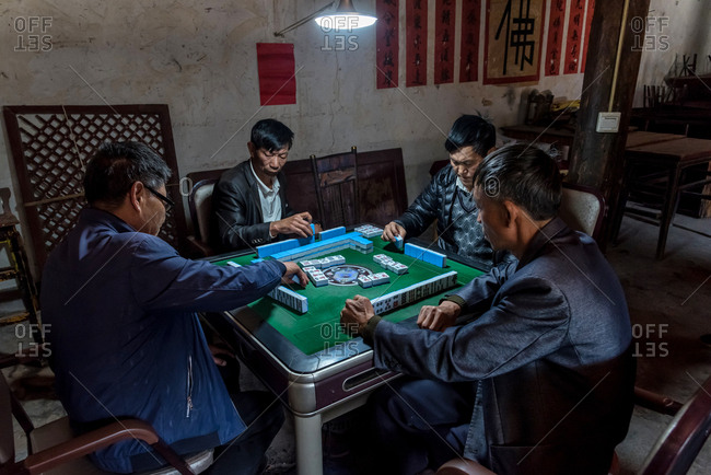 March 14, 2019: Group of elderly Chinese men playing mahjong in Yunnan, China