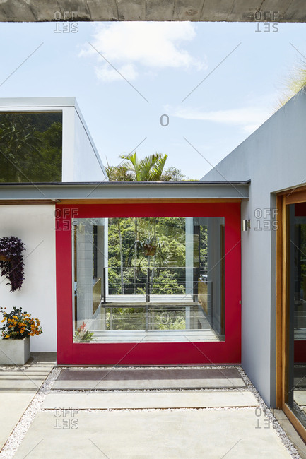 Costa Rica, Central America - July 30, 2019: Red trim around large window on exterior of modern home