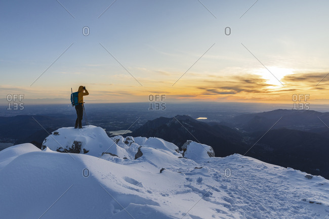 Mountaineer standing on top of a snowy mountain enjoying the view- Lecco- Italy