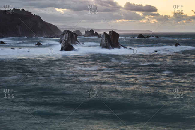 Picturesque majestic raging waters of bay breaking rocks on beach of Silence O Gaviero in Spain