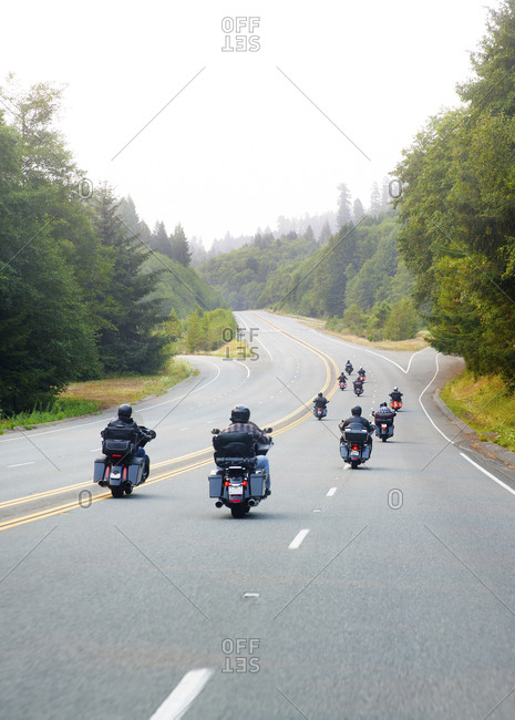 Motorcyclists driving south on Highway 101 near a redwood forest, California, USA