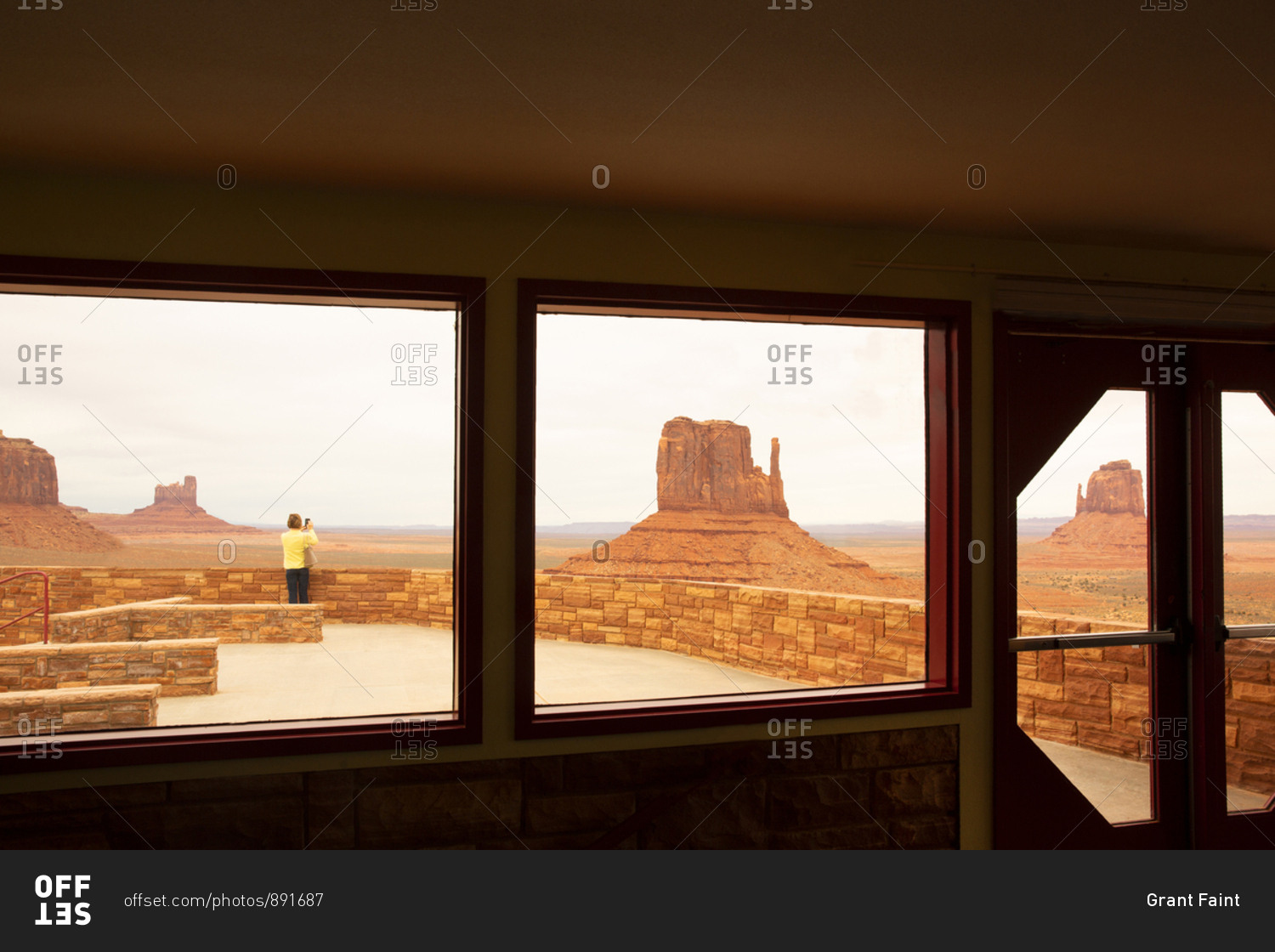 Tourist taking pictures of Monument valley stone formations in Navajo Tribal park,