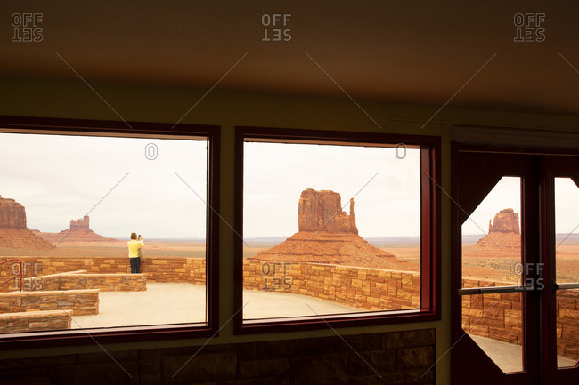Tourist taking pictures of Monument valley stone formations in Navajo Tribal park,