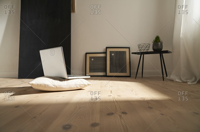 Laptop on cushion and wooden floor in a modern room
