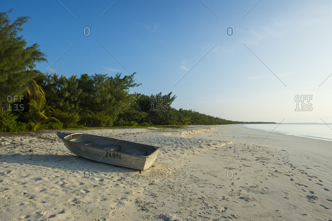 May 11, 2016: Boat moored at white sand beach during sunset- Ouvea- Loyalty Islands- New Caledonia