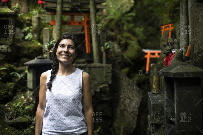 Japan- Kyoto Prefecture- Kyoto City- Portrait of female tourist smiling while visiting Fushimi Inari-taisha temple