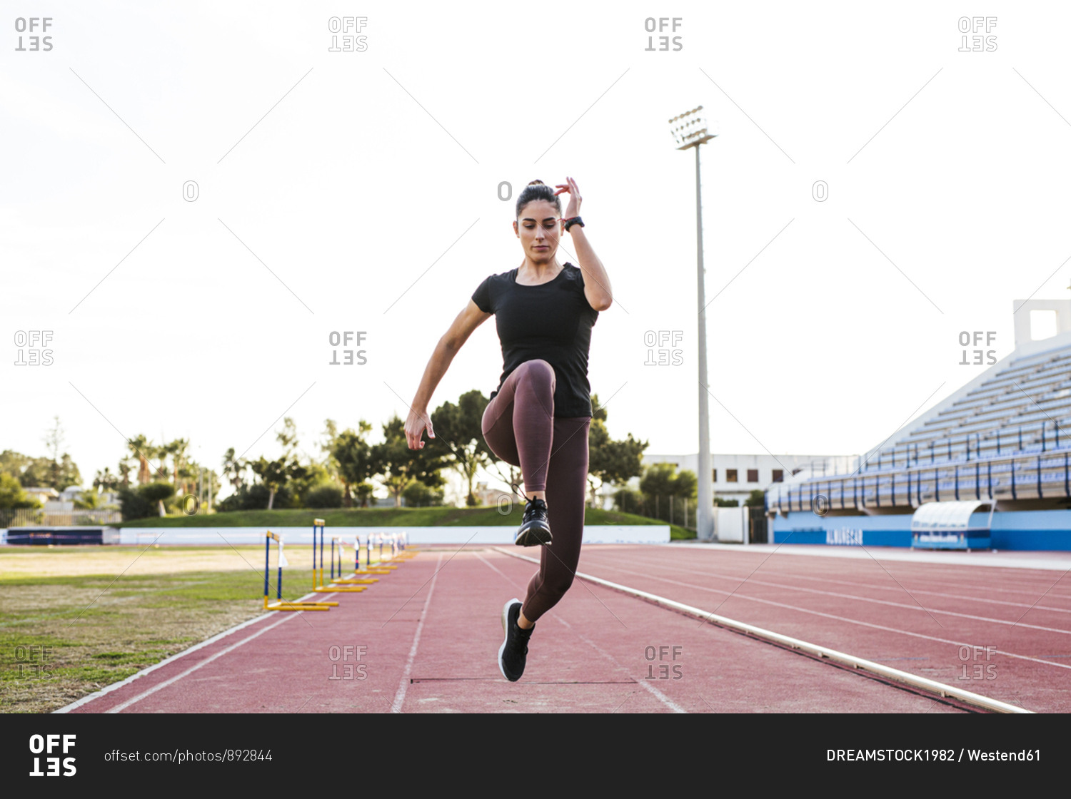 Young woman on tartan track running