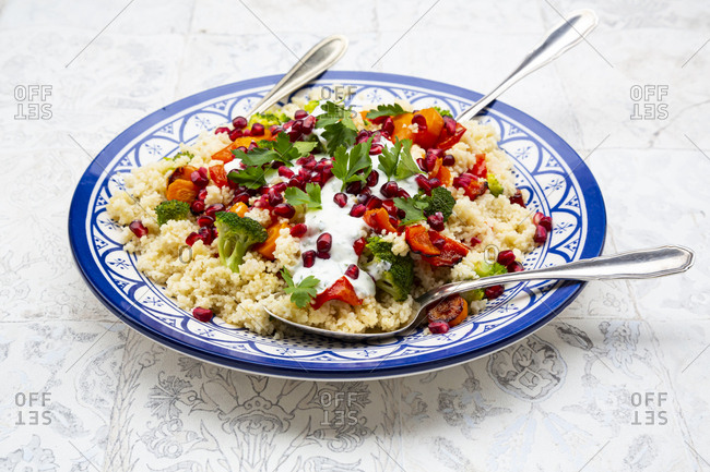 Couscous with grilled vegetables: carrots- peppers and broccoli and yoghurt-mint sauce- parsley- pomegranate seeds