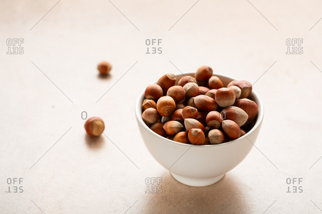 Close up of hazelnuts in a bowl on stone surface