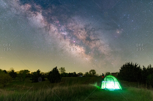 backcountry camping in a lamp-lit tent under stars and the Milky way