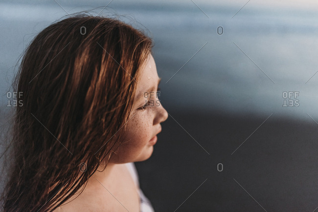 Portrait of cute red headed girl with freckles looking to horizon