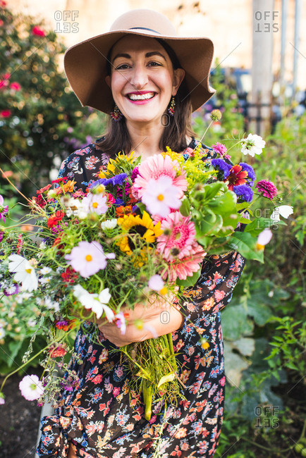 happy smiling woman in garden with flowers