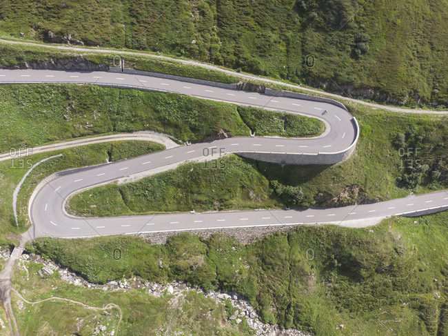 Birds eye view of a cyclist speeding down a curvy Swiss highway