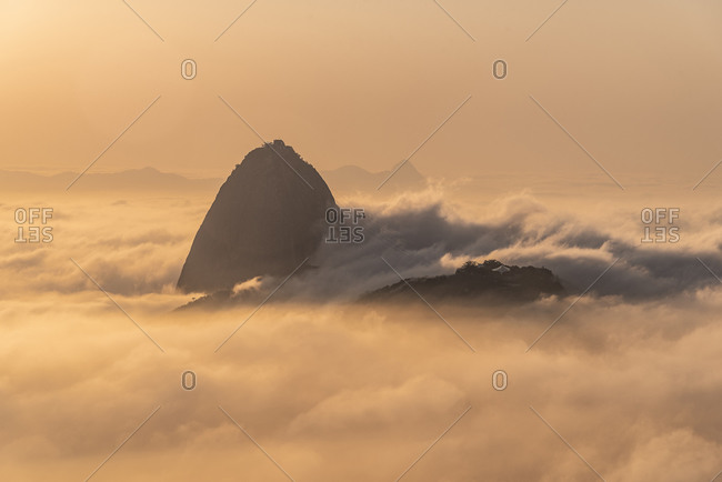 Beautiful landscape of sunrise and mountain rising above low clouds