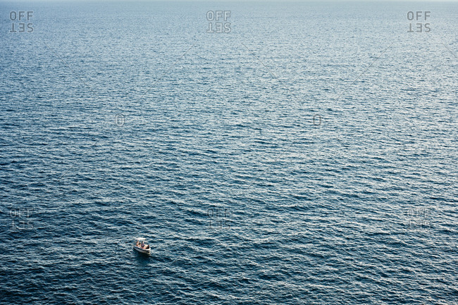 Distant boat in boundless blue sea