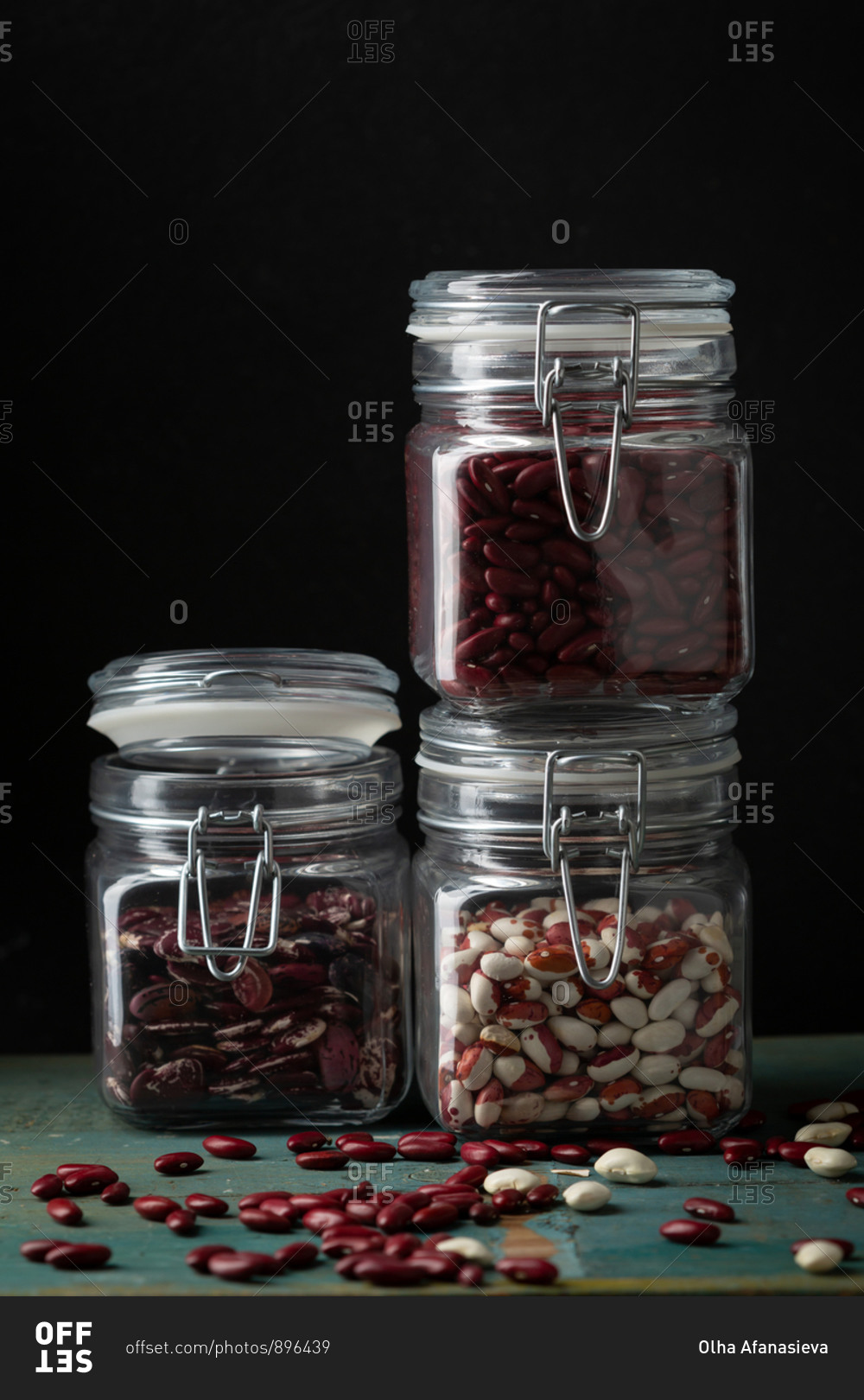 Close up of  storage jars with beans on wooden surface