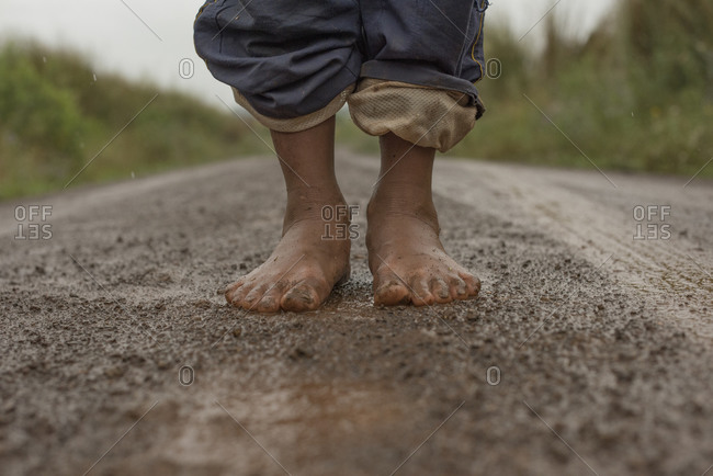 Muddy barefoot feet of a indigenous kid in southern brazil dirt road