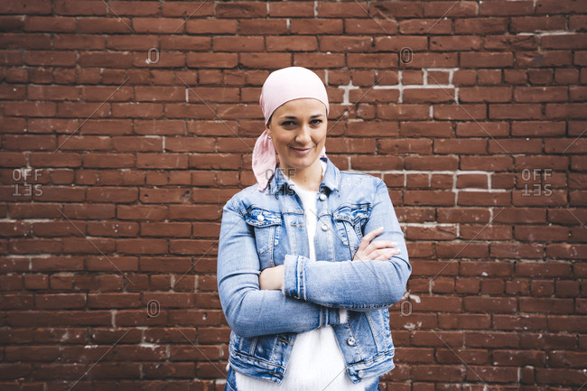 Woman with cancer bandana in front of brick wall in New York- USA