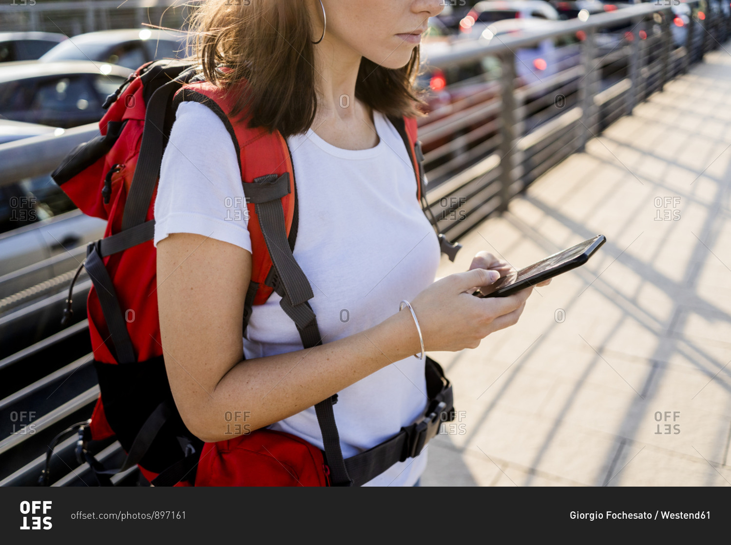 Young female backpacker using smartphone in the city- Verona- Italy