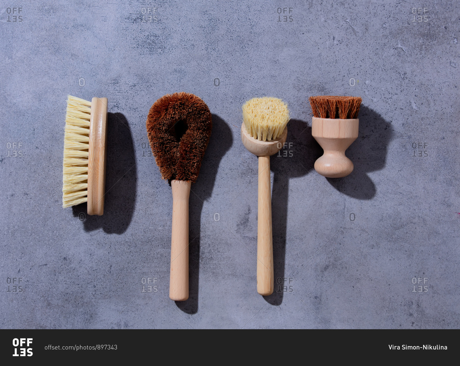 Eco-friendly wooden brushes for washing dishes on gray background