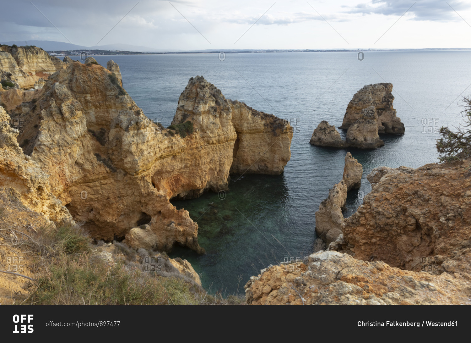 Portugal- Faro District- Lagos- Coastal cliffs at dawn with clear line ...