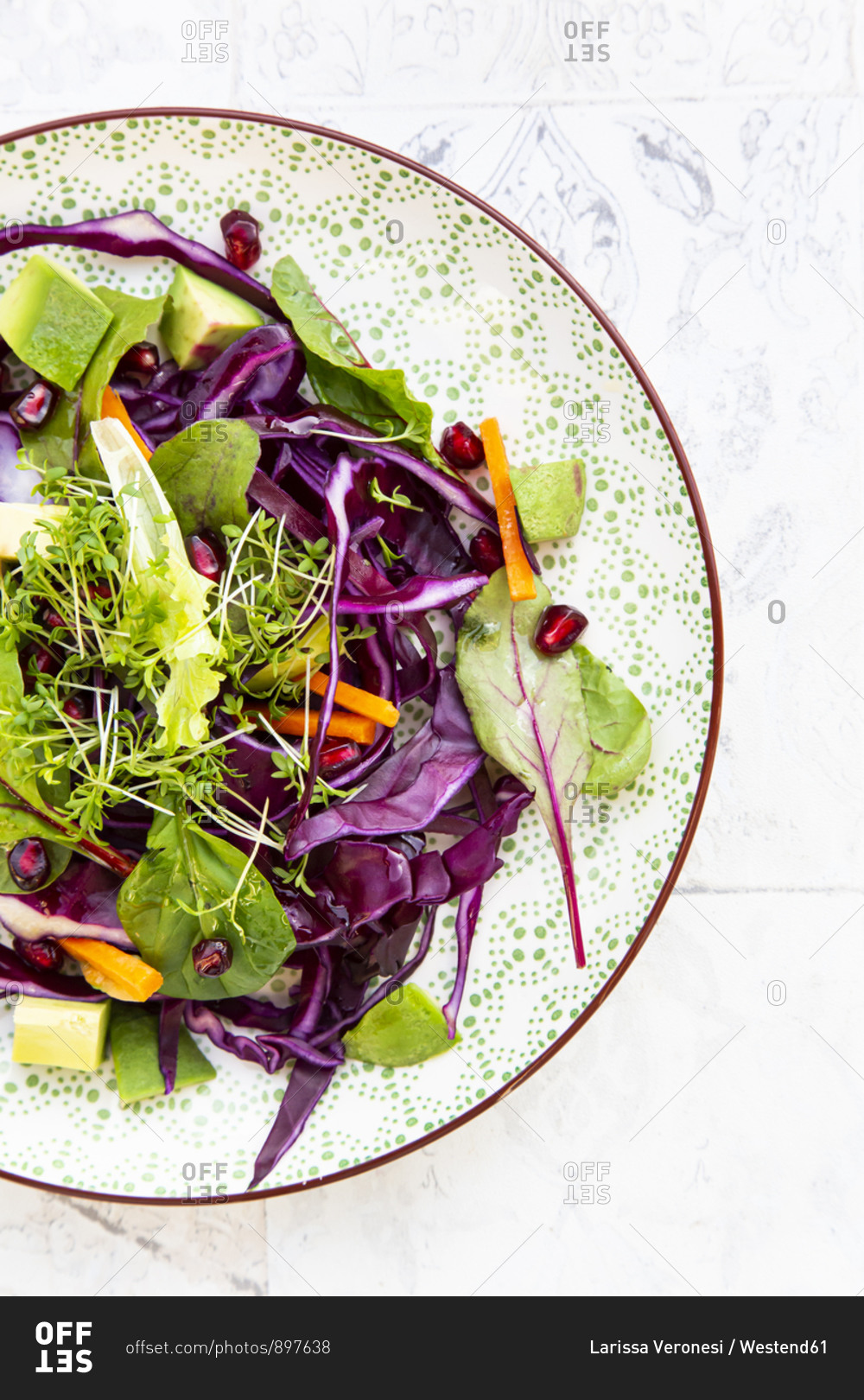 Salad with red cabbage- carrots- lettuce leaves- avocado- pomegranate seeds and cress