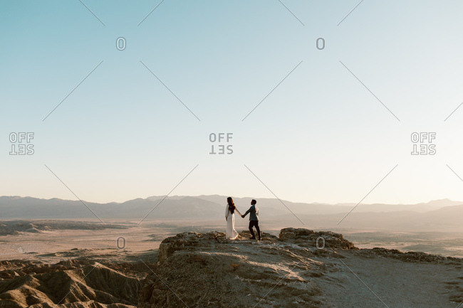 Couple holding hands at a desert overlook