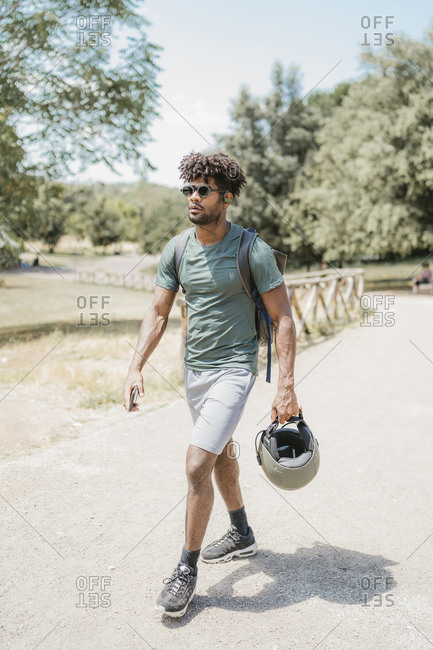 Young man with helmet walking in park