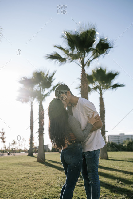 Kissing teenage couple at backlight