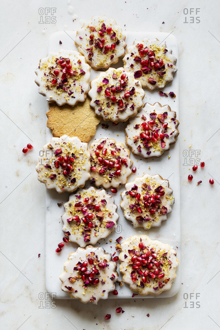 Gluten-free Sugar Cookies with eggless glaze decorated with pomegranate seeds, rose petals and pistachio