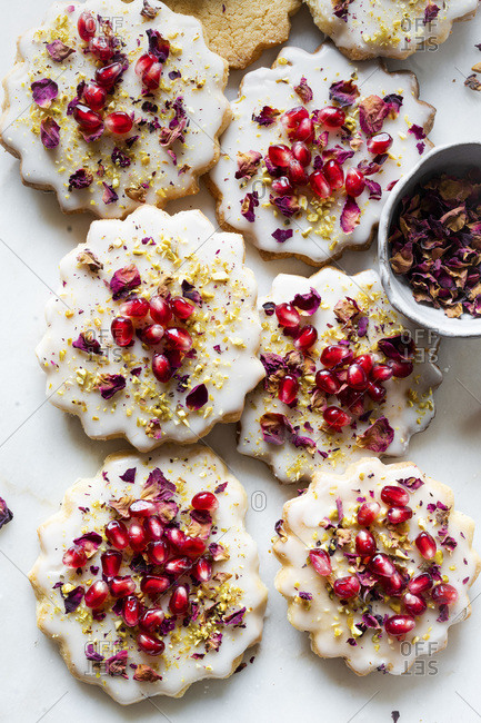Gluten-free Sugar Cookies with eggless glaze decorated with pomegranate seeds, rose petals and pistachio