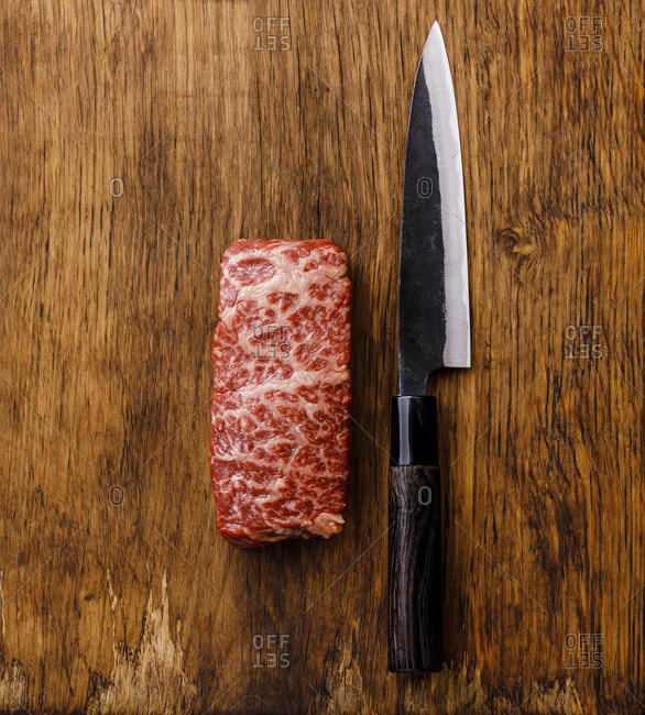 Raw fresh marbled meat Steak Wagyu beef and kitchen knife on wooden background