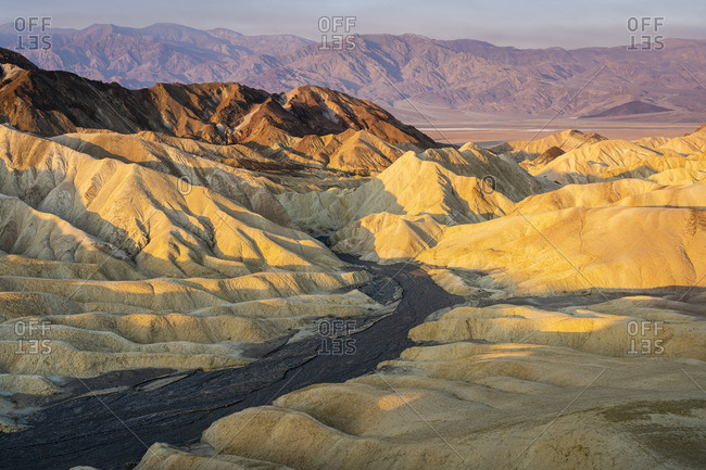 Scenic view of natural rock formations at Zabriskie Point during sunrise, Death Valley National Park, Eastern California, California, USA