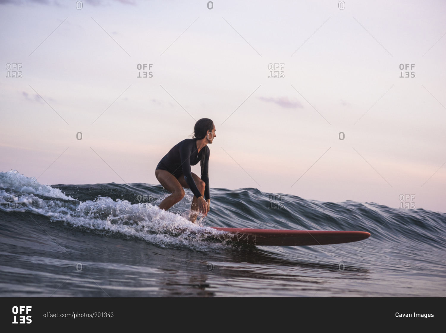 Water women friends surfing together at sunset