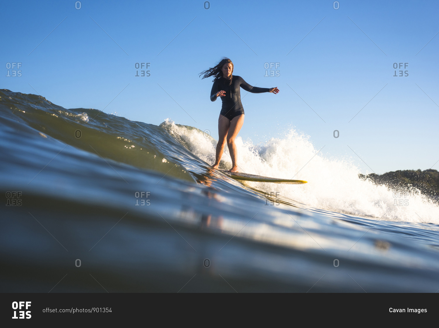 Woman surfing at sunset