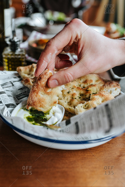 Hand dipping focaccia in sour dip