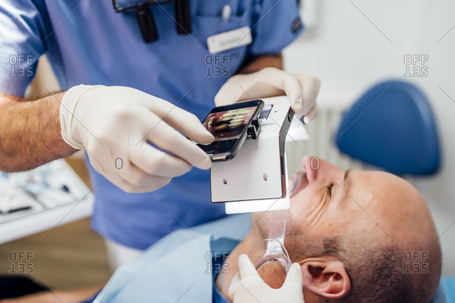 Close-up of dentist taking photo of dentures with special photographic apparatus