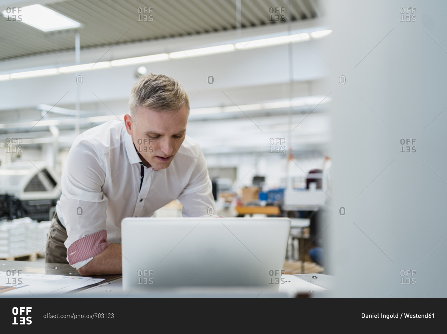 Businessman using laptop in factory