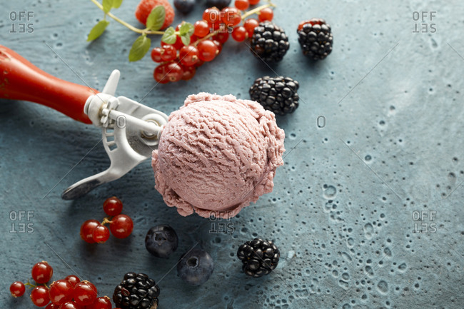 Raspberry ice cream on scoop and fresh fruits