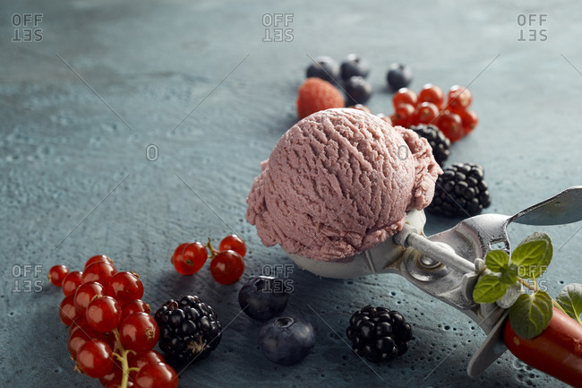 Raspberry ice cream on scoop and fresh fruits